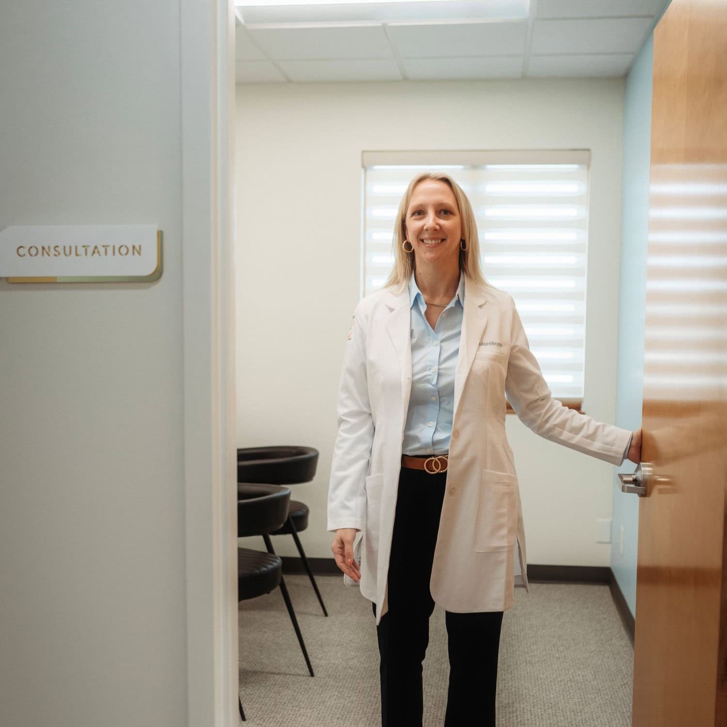 Audiologist opening consultation room door at Tinnitus Relief Center.