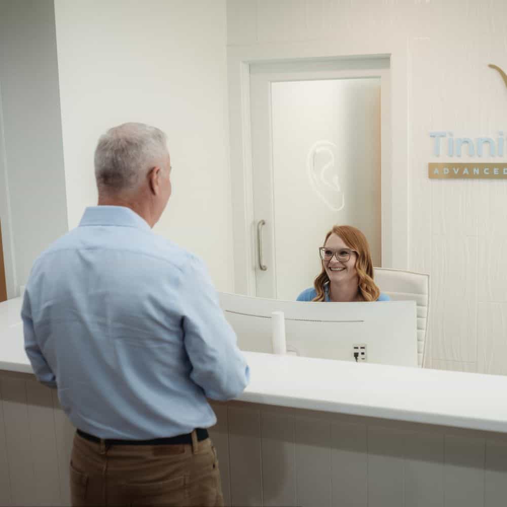 Patient consulting with audiologist at Tinnitus Relief + Advanced Audiology Center.