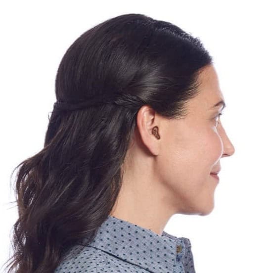 Woman with hearing aid in ear, promoting tinnitus relief services.